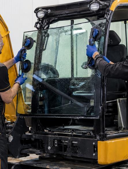 Installing JCB Excavator Cab Glass with Glass Lifters Technicians installing new JCB excavator cab glass using glass lifters